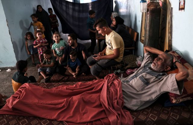 Palestinians fleeing Israeli air strikes take refuge in a school run by the United Nations in Gaza City
