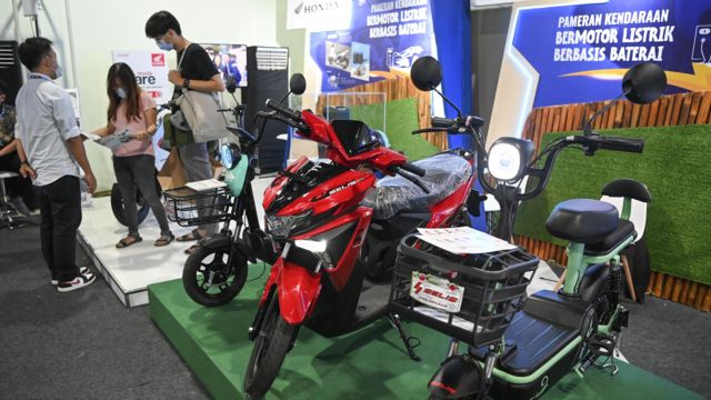 Petugas memberikan penjelasan kepada pengunjung terkait sepeda motor listrik pada Pameran Kendaraan Listrik Berbasis Baterai dalam rangkaian KTT G20 di Bali Collection, Nusa Dua, Bali, Sabtu (12/11)