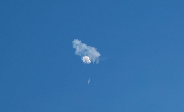 Fumaça e resto de balão no céu azul