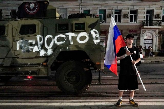 Ростовчанин с российским флагом на фоне военной техники вагнеровцев