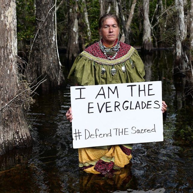 Una persona con un cartel a favor de proteger los Everglades