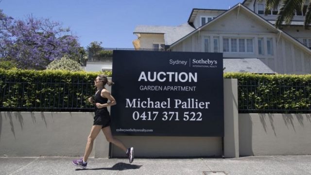 Mujer corre frente a una casa en australia 