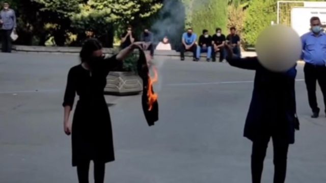 روز ۲۳ مهر ۱۴۰۱ یک دختر در دانشگاه تهران مقنعه‌اش را می‌سوزاند