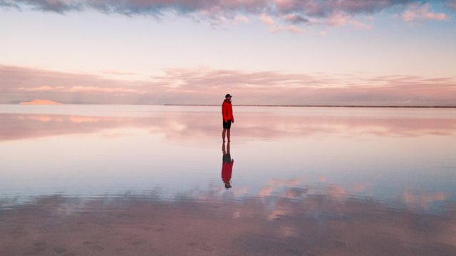 Una persona sola de pie en medio de una playa