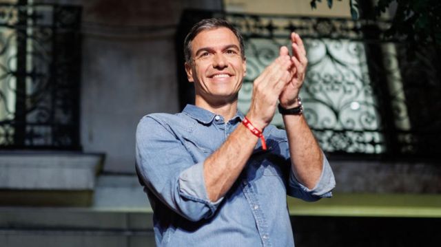 Pedro Sánchez, presidente del gobierno español y líder del PSOE, aplaude desde el balcón de su partido