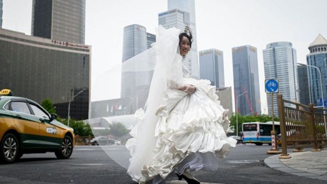 زنی با لباس عروس در خیابان می‌دود و می‌خندد