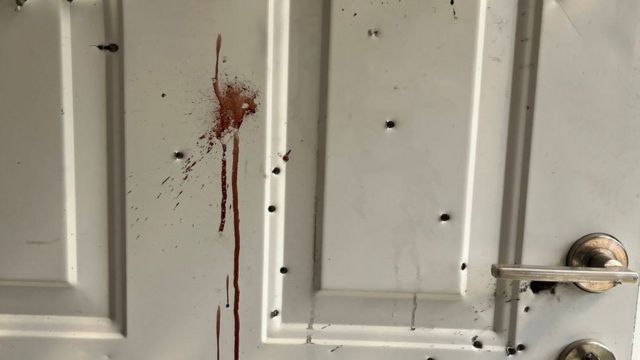 Дверь со следами пуль и крови