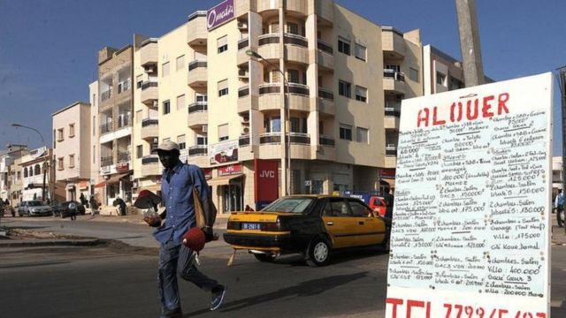une affiche indiquant "A louer" devant un immeuble vide dans un quartier résidentiel de Dakar