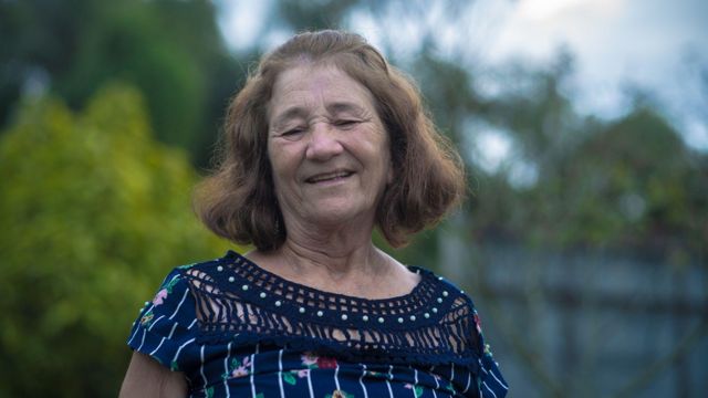 Adelina sorrindo para foto em praça