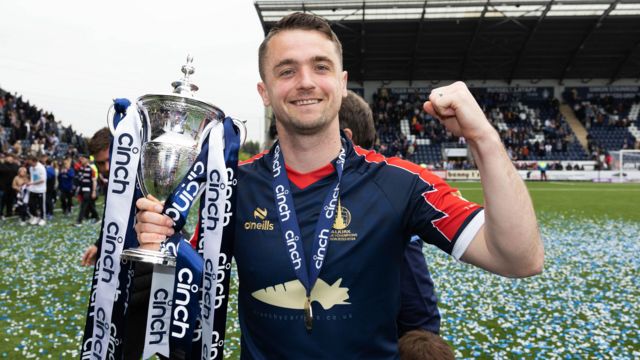 Falkirk's Stephen McGinn  with the cinch League One trophy during a cinch League One match