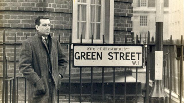 Fernando Sabino em frente à Embaixada do Brasil em Londres; ele está ao lado de placa com o nome da rua