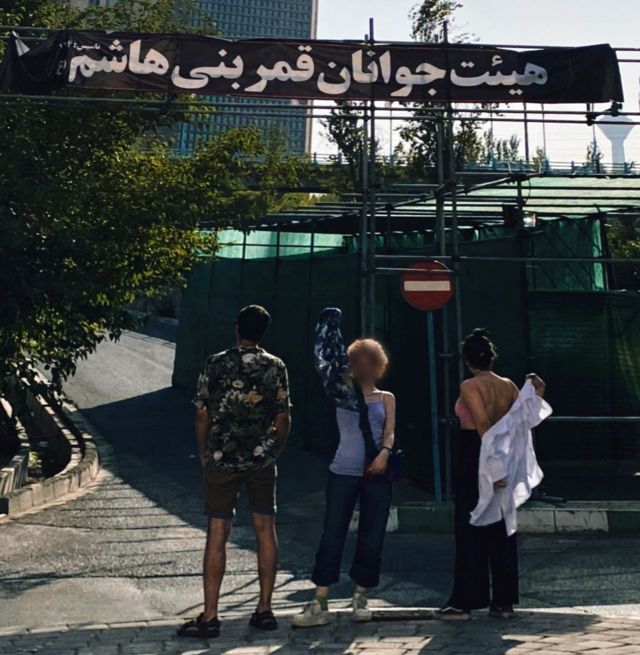 سه جوانی که با پوشش اختیاری مقابل یک مکان مذهبی عکس گرفتند