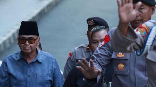 Pimpinan Pondok Pesantren Al Zaytun Panji Gumilang (tengah) berjalan saat akan menjalani pemeriksaan di Bareskrim Mabes Polri, Selasa (01/08).