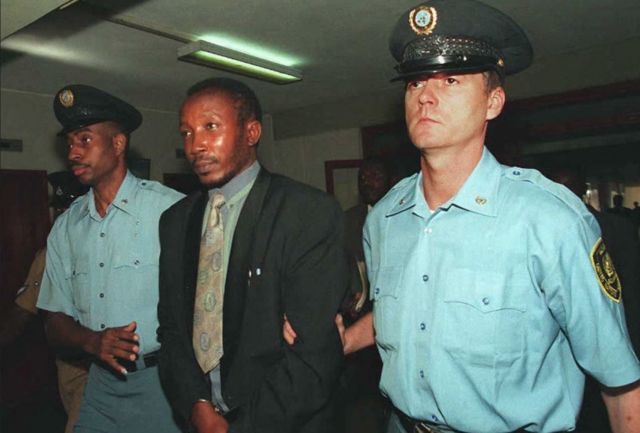 Jean-Paul Akayesu é escoltado até o Tribunal Penal Internacional para Ruanda por agentes de segurança das Nações Unidas