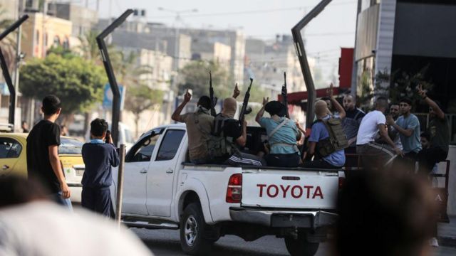 Combatientes de Hamás regresan a la Franja de Gaza en una camioneta con fusiles en el aire 