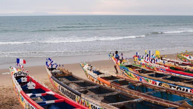 Beach with a wide view of the Atlantic Ocean with wooden boats in the foreground.