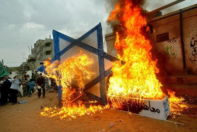 Partidarios de Hamás queman una estrella de David, símbolo del judaismo.