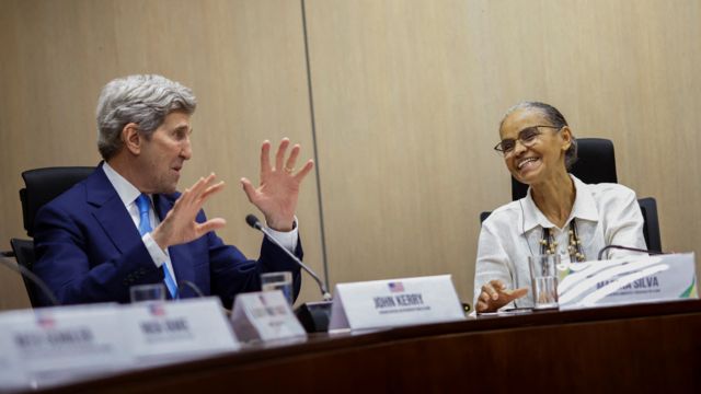 Kerry e Marina Silva rindo em reunião, lado a lado diante de mesa