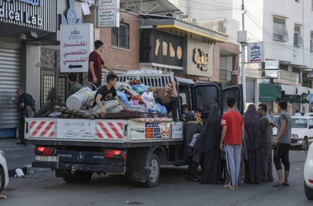 Palestinos abordan una camineta cargada de pertenencias