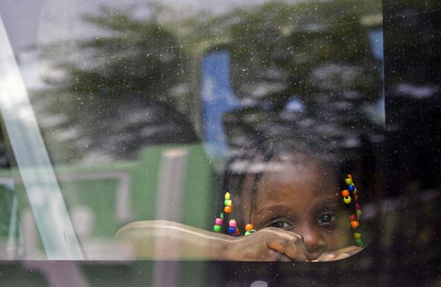 Una niña haitiana mira desde la ventanilla de un vehículo mientras su familia es transportada para ser repatriada voluntariamente en Santo Domingo el 29 de junio de 2015. 