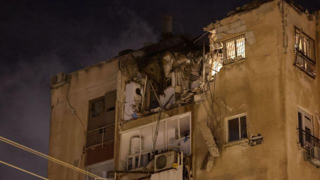 A building in Tel Aviv is damaged by a rocket fired by Palestinian militants from the Gaza Strip on October 7