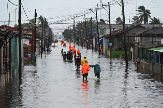 La gente camina por una calle inundada en Batabanó, provincia de Mayabeque, Cuba.