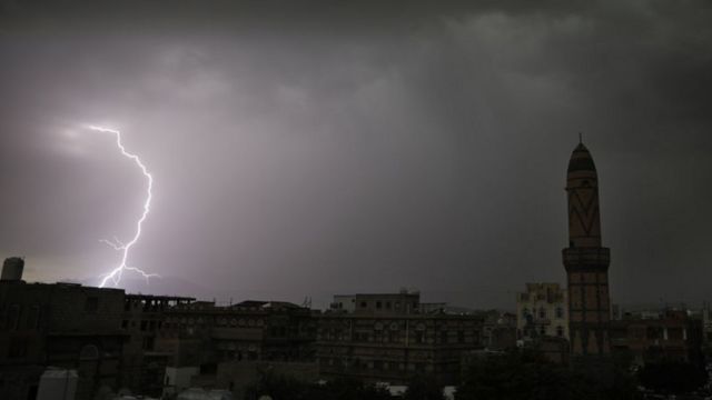 Raio em cidade nublada à noite