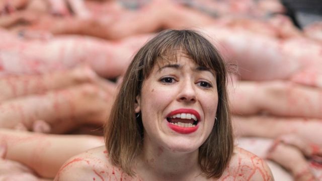 An activist naked and with paint that simulates blood lies on the ground during a protest demanding the non-use of animal skins and the closure of fur farms in Puerta del Sol, Madrid