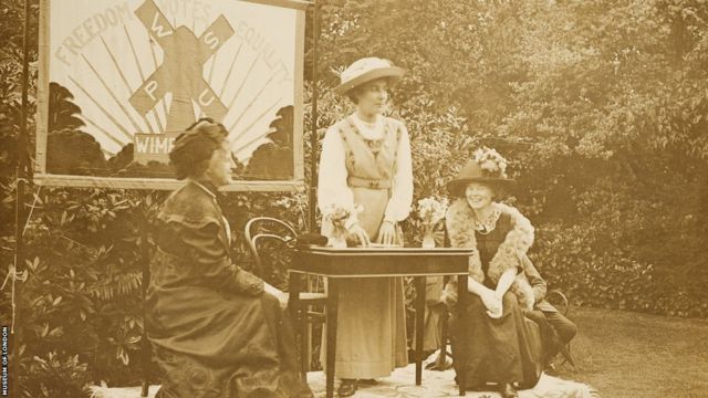 Rose Lamartine Yates discursando em uma reunião das suffragettes na sua casa, em Dorset Hall (Londres)