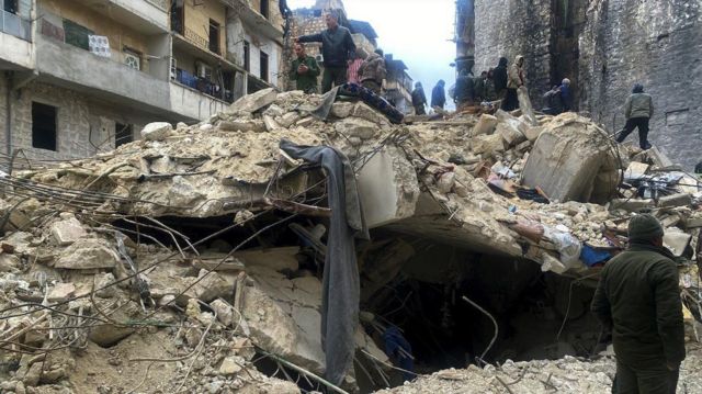 Halep'te çöken bir binada sağ kurtulanları arayanlar. 