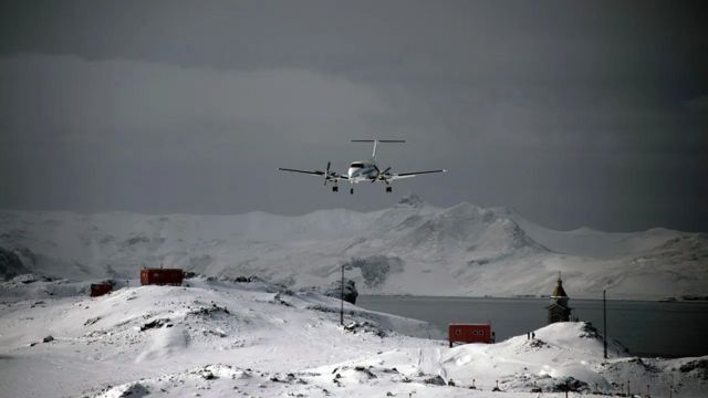 Avião próximo a pista em dia nublado na Antártida