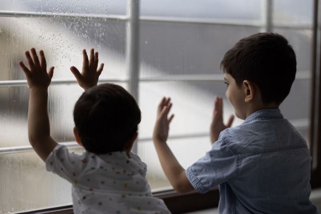 Crianças olhando pela janela