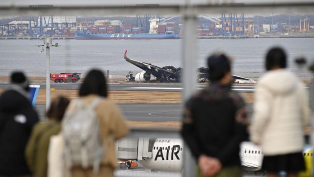 Pasajeros miran el avión calcinado