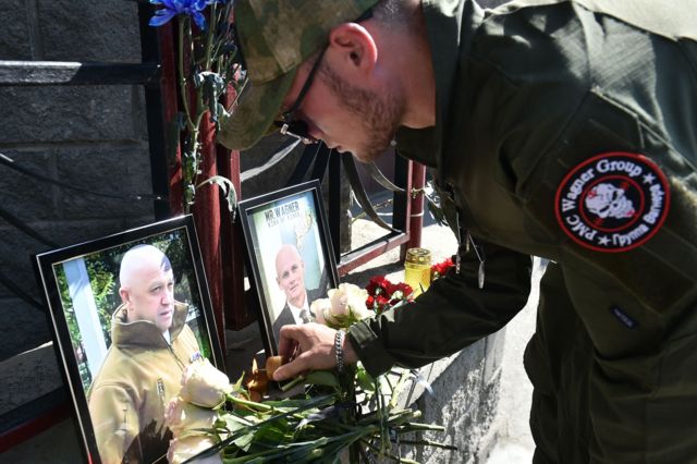 Un hombre deja flores ante una foto de Prigozhin.