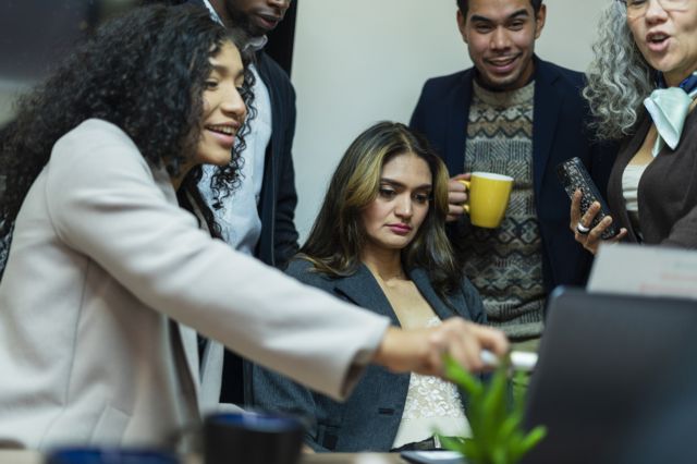 Diversas pessoas de multiplas etnias em frente a um computador