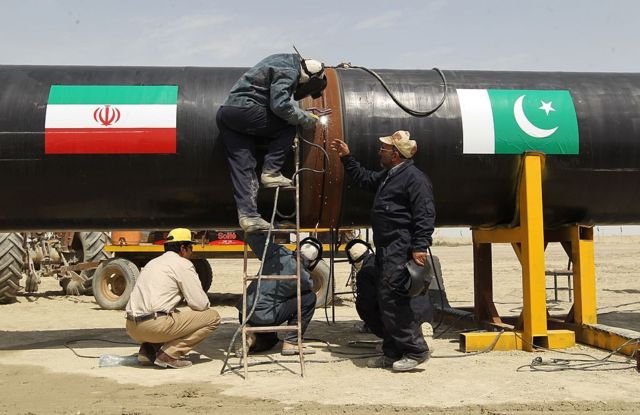 کارگران در حال جوش دادن دو لوله گاز بین ایران و پاکستان