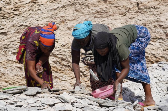 Des femmes trient des pierres en plein soleil sur la mine de Bantaco. 