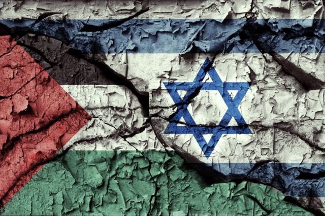 duvara boyanmış ve soyulan Filistin ve İsrail bayrakları