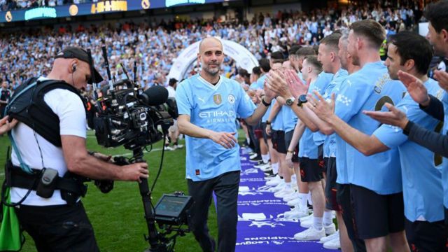 Pep Guardiola, manager of Manchester City, congratulates staff