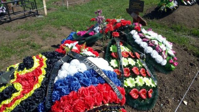 Coroa de flores com as cores da bandeira russa sobre túmulo
