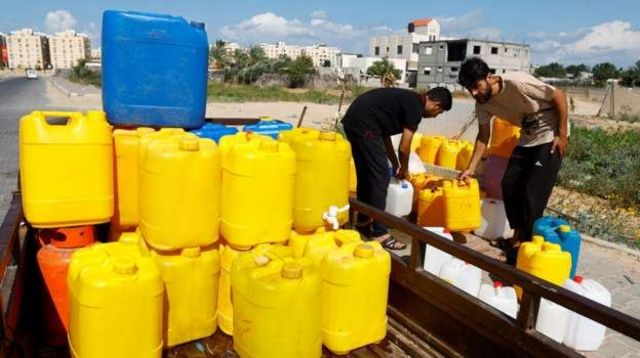 Palestinos se reúnem para coletar água, em meio à escassez de água potável, em Khan Younis, no sul da Faixa de Gaza, em 15 de outubro de 2023