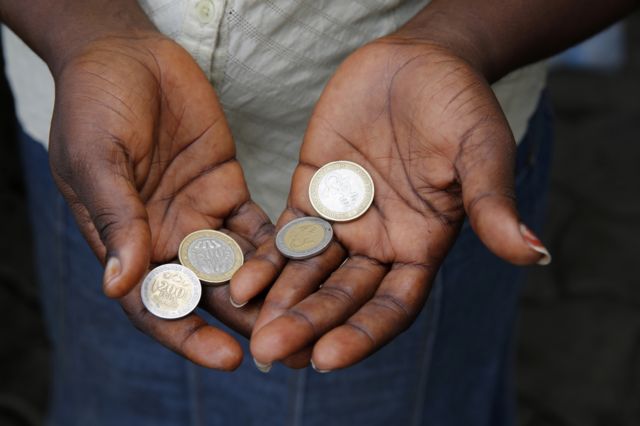 Two hands holding coins