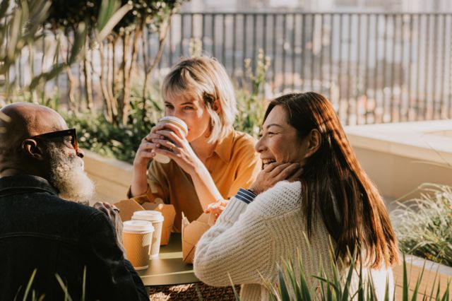 Un grupo de amigos tomando café al aire libre.