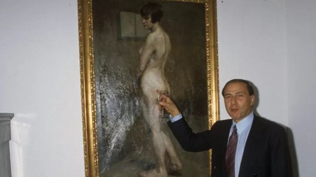 Silvio Berlusconi aponta um de seus quadros