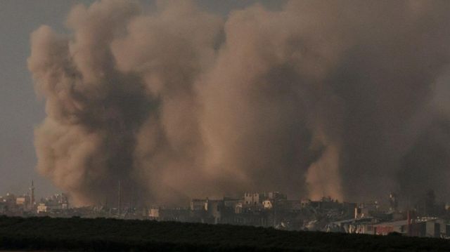 Horizonte de cidade repleta de fumaça de bombardeios