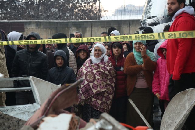 People watch as rescue operations take place on a site after an earthquake in Diyarbakir, Turkey on 6 February 6 2023