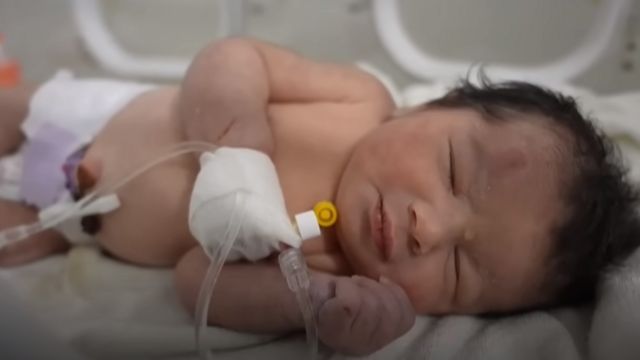 Gabar yar oo ay ku dhagganeyd xuddunta hooyadeed