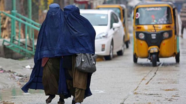 Dos mujeres totalmente cubiertas avanzan juntas en una calle de Afganistán