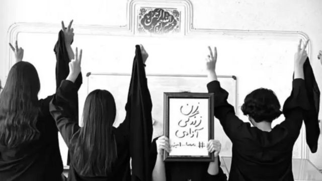 چند دختر دانش‌آموز در کلاس درس حجابشان را برداشته‌اند و شعار زن، زندگی، آزادی در دست دارند