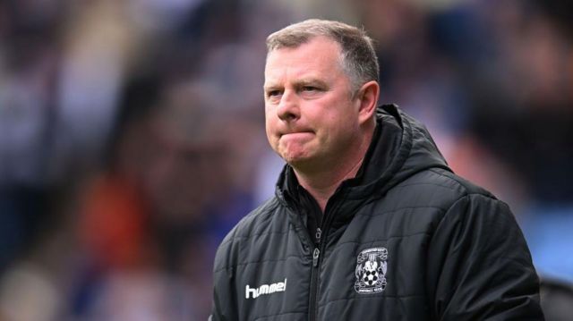 Mark Robins looks on